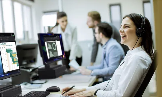 une femme travaillant sur son ordinateur de bureau avec un casque 